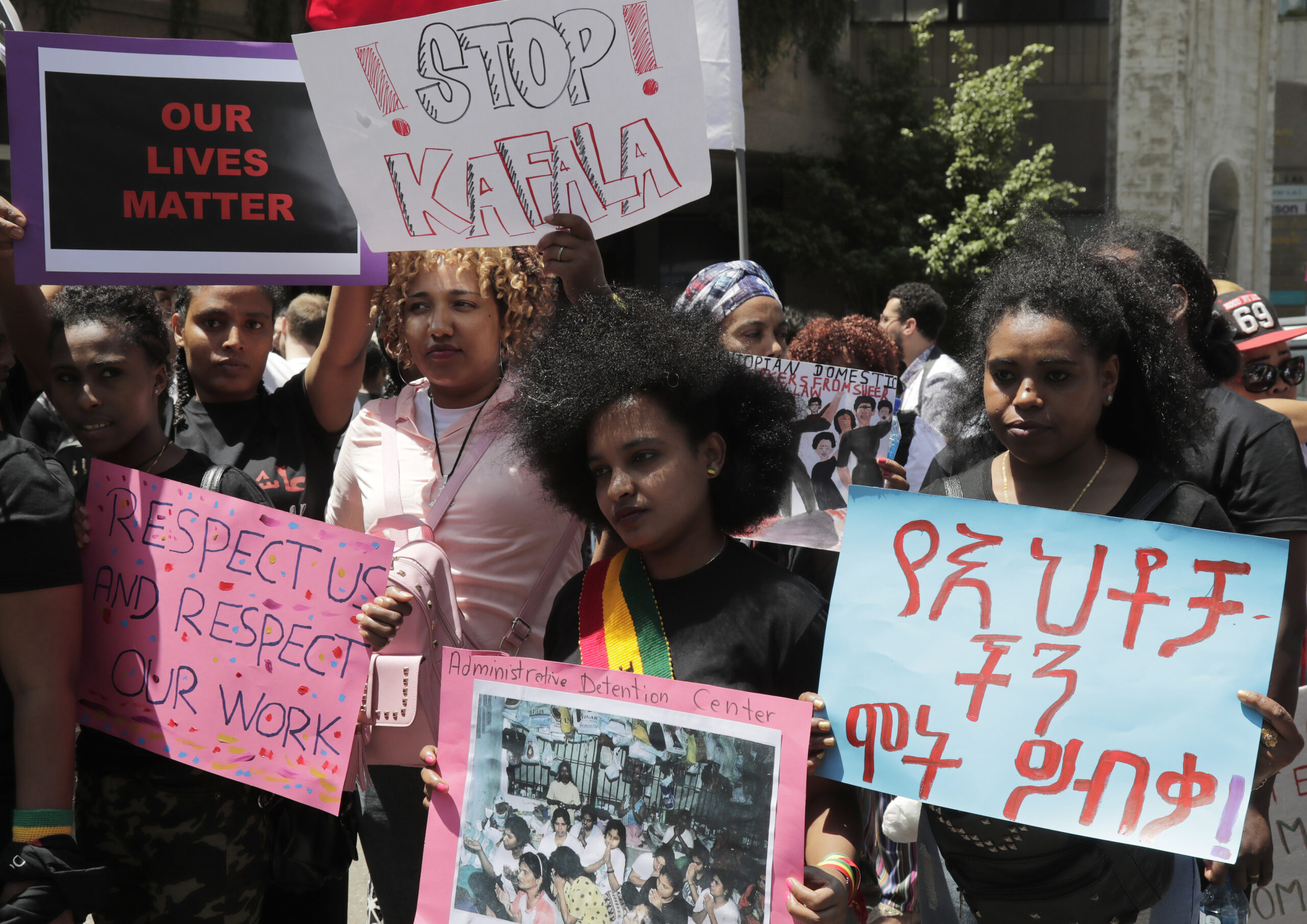 Migrant domestic workers carry placards during a protest in the Lebanese capital Beirut on May 5, 2019, to call for the abolishment of the sponsorship (kafala) system and for the inclusion of domestic workers in Lebanese labour laws. - Domestic workers in Lebanon, which hosts more than 250,000 registered domestic workers from countries in Africa and Asia, are excluded from the labour law. They instead obtain legal residency though their employers' sponsorship under the so-called "kafala" system. (Photo by ANWAR AMRO / AFP)